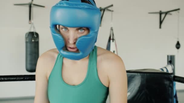Retrato en cámara lenta de una mujer joven con casco de seguridad de pie en el ring descansando — Vídeos de Stock