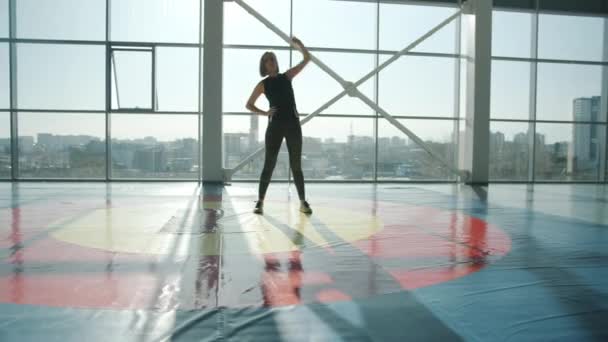 Piękna młoda sportowiec noszenie modne legginsy i top robi rozgrzewkę w siłowni — Wideo stockowe