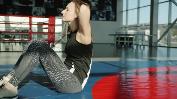 Cámara lenta de chica atractiva en entrenamiento de ropa deportiva músculos abdominales haciendo abdominales en el gimnasio — Vídeos de Stock