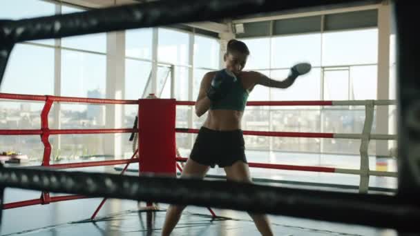 Piękna kobieta bokser szkolenia w siłowni sam ruch shadowboxing noszenie rękawic i odzieży sportowej — Wideo stockowe
