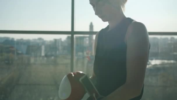 Attraente giovane pugile che indossa guanti in piedi contro la finestra panoramica in palestra — Video Stock
