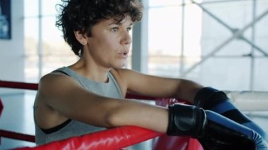 Dövüş sanatları dövüşçüsü güzel kız. Spor salonunda ringin köşesinde dinleniyor.