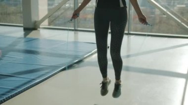 Güzel bir bayanın ip atlarken spor yaparken ağır çekimde zıplaması.