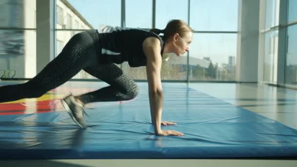 Spor salonunda iç mekanda egzersiz yapan motive olmuş sporcu kadının yan görüntüsü — Stok video