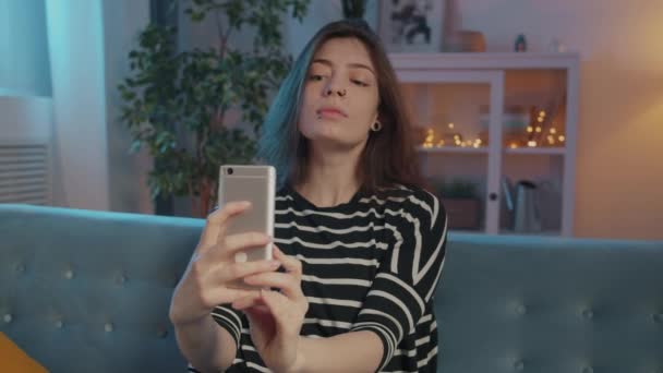Mouvement lent de jolie étudiante prenant selfie avec caméra smartphone dans la chambre noire — Video