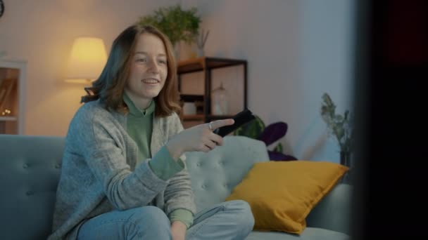 Női diák tévéműsort néz éjszaka távirányítóval élvezi szabadidő egyedül — Stock videók