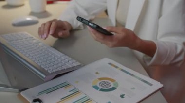 Cep telefonuyla konuşan ve karanlık ofiste bilgisayarla çalışan hırslı genç iş kadını.