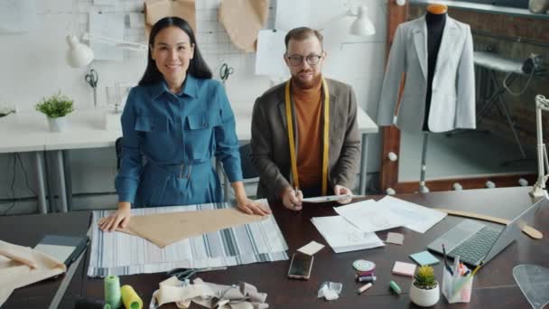 Top view of two people dressmakers looking at camera standing in workplace together — Stock Video