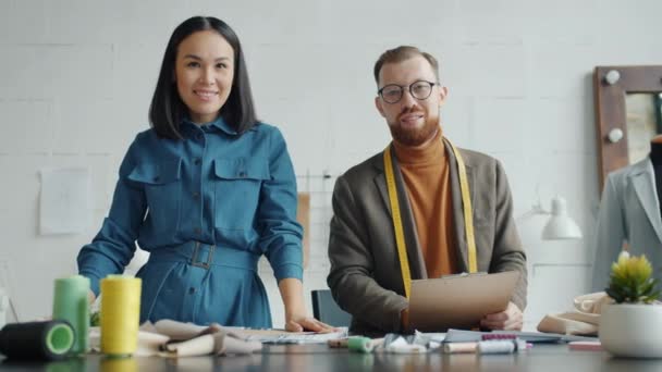 Udane krawcy mężczyzna i kobieta uśmiechnięci stojąc razem w miejscu pracy — Wideo stockowe