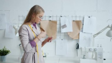 Modern kıyafet tasarımcısı stüdyoda çalışan yeni kıyafet koleksiyonu için kumaş seçiyor.