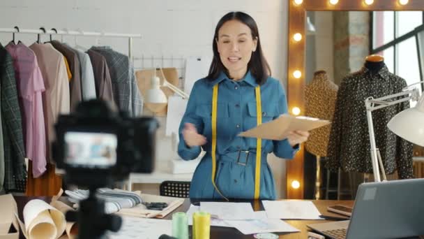 Talentvolle naaister opname video voor online vlog tonen schetsen op nieuwe kleren — Stockvideo