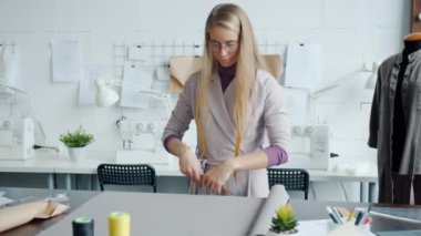 Yaratıcı kadın terzinin portresi yeni kıyafetler için malzeme seçiyor.