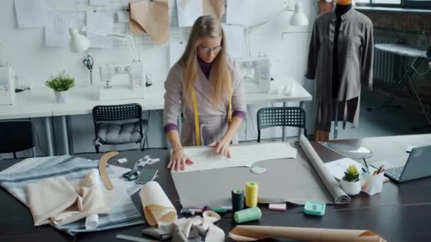 Zeitlupenporträt einer professionellen Näherin, die im Atelier neue modische Kleidungsstücke herstellt — Stockvideo