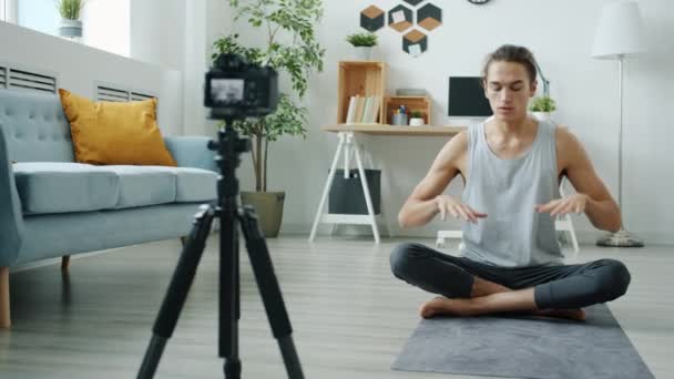 Instrutor de ioga gravação aula on-line demonstrando asana e falando usando a câmera no tripé — Vídeo de Stock