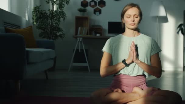 Szép jógi portréja, amint otthon lótuszpozícióban ülve meditál. — Stock videók