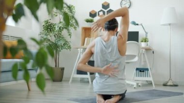 Esnek erkek sporcunun arkadan bakışı. Dairede yoga yapıyor.