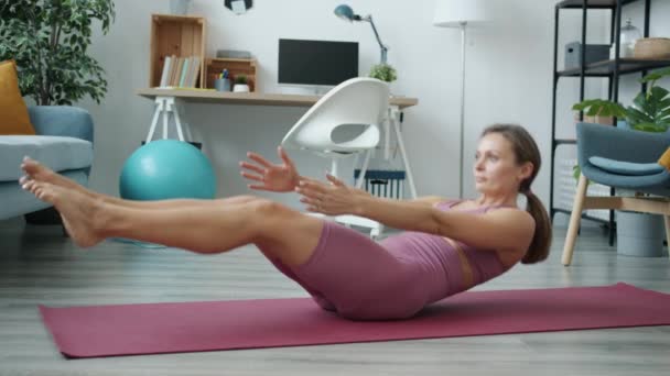 Retrato de chica atractiva en ropa deportiva de moda entrenamiento de los músculos abdominales haciendo crujidos en casa solo — Vídeos de Stock