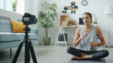 Karışık ırk adamı internetten yoga öğretiyor. Evde kamera kullanıyor.
