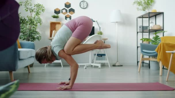 Rallentare il movimento di forte ragazza facendo handstand poi plank posizione formazione da solo in appartamento — Video Stock