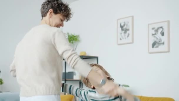 Menino feliz dançando com a jovem mãe gostando de música no tempo de lazer juntos — Vídeo de Stock