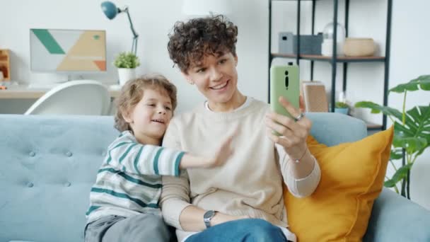 Família feliz mãe e filho falando e acenando mão fazendo videochamada on-line em casa — Vídeo de Stock