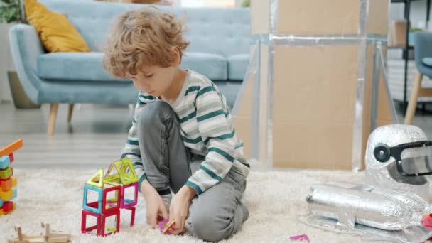 Niño adorable jugando con juguete moderno solo en el apartamento — Vídeos de Stock