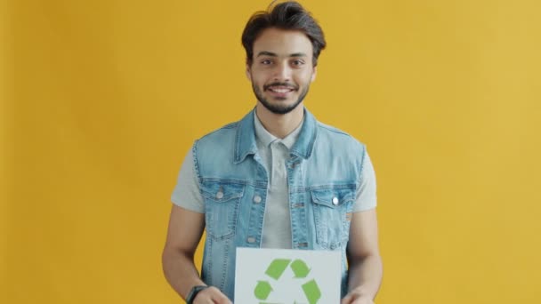 Fröhlicher Inder mit Recycling-Symbol für Umweltschutz und lächelnd — Stockvideo