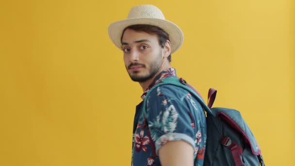 Retrato en cámara lenta del guapo turista árabe girando hacia la cámara pidiendo seguir hablando y saludando con la mano — Vídeos de Stock
