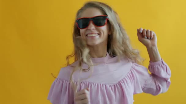Slow motion van jonge vrouw dragen zonnebril dansen het hebben van plezier — Stockvideo