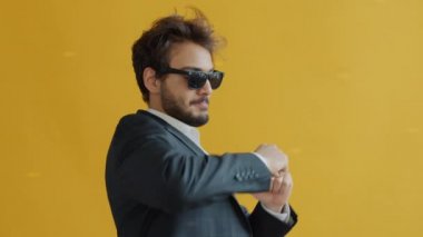 Aydınlanmış arka planda dans eden neşeli Hintli adamın yavaş çekim portresi.