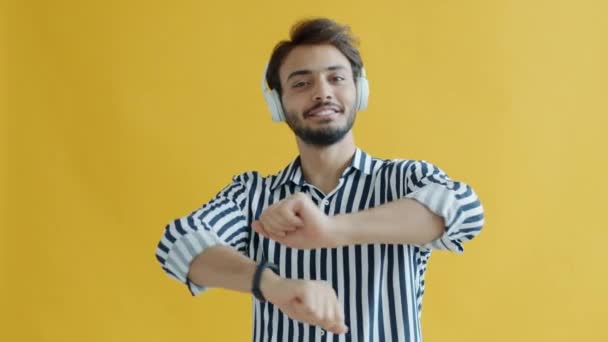 Kulaklık takarak dans eden arap öğrencinin yavaş çekim portresi. — Stok video