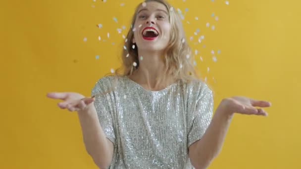 Zpomalený film portrét šťastné ženy házení konfety a foukání na třpytky baví — Stock video
