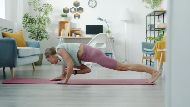 Långsam rörelse av skicklig ung kvinna stretching kropp och motion inomhus — Stockvideo
