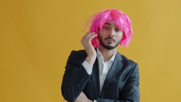 Retrato em câmera lenta do homem de raça mista tirando a peruca rosa e saindo se sentindo infeliz — Vídeo de Stock