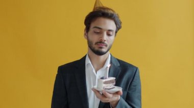 Orta Doğulu mutsuz bir adamın doğum günü pastasına mum üfleyen portresi sıkılıyor.