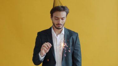 Parti şapkalı, Bengal ışığı sallayan sıkıcı bir Arap 'ın ağır çekim portresi.