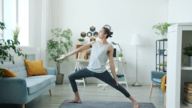 Evde yoga yapan deneyimli bir sporcunun portresi egzersize odaklanmış.