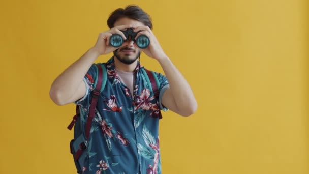 Turis Timur Tengah dengan ransel yang sedang berjalan sambil melihat dengan teropong tersenyum — Stok Video