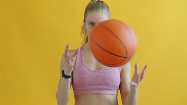 Portret młodej kobiety bawiącej się koszykówką i patrzącej w kamerę — Wideo stockowe