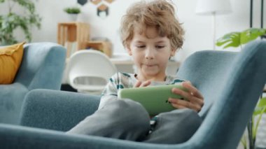 Akıllı telefonlu çocuk evde ekranlara dokunarak mobil oyun oynuyor