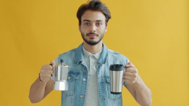 Człowiek z Bliskiego Wschodu wlewa kawę do kubka termosu wielokrotnego użytku, promując koncepcję zero odpadów — Wideo stockowe