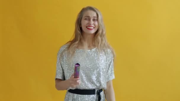 Portrait au ralenti d'une fille heureuse jetant des confettis et dansant sautant en riant avec des paillettes brillantes tombant — Video