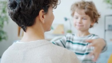Yavaş çekimde sevimli çocuk kucaklar genç anne evde sevgisini ifade eder.