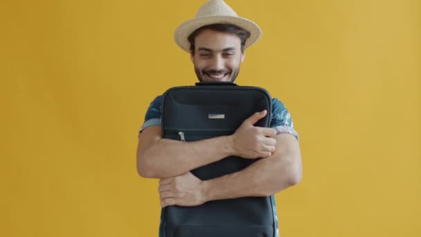 Portrait au ralenti d'un jeune homme joyeux embrassant une valise se sentant heureux pendant les vacances — Video