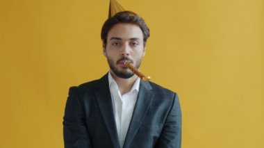 Üzgün Hintli adam parti şapkası takıyor, etrafa bakıyor ve sıkılıyor.