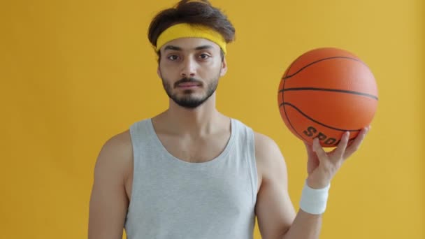 Retrato de sério esportista do Oriente Médio segurando basquete e olhando para a câmera — Vídeo de Stock