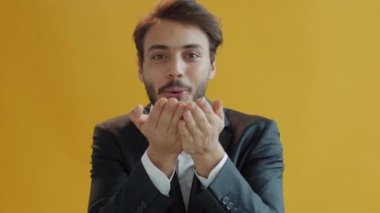 Kaygısız Arap 'ın portresi kameraya gümüş konfeti üflüyor ve dans ediyor.