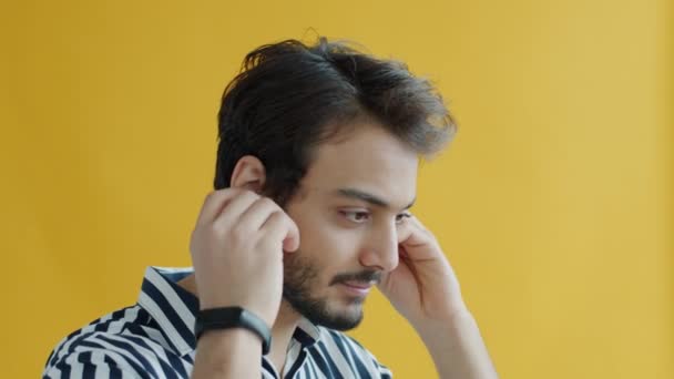 Movimiento lento del hombre de Oriente Medio con auriculares inalámbricos bailando escuchando música — Vídeo de stock