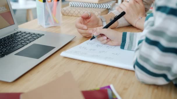 Close-up van de handen kind en moeder studeren wiskunde doen huiswerk met behulp van laptop thuis — Stockvideo