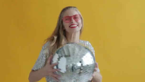 Mouvement lent de la jeune femme portant des lunettes de soleil élégantes dansant avec boule disco — Video